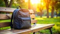 Black Backpack on a Park Bench in Golden Hour Sunlight Royalty Free Stock Photo