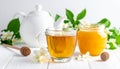 A jar of honey and a glass of hot jasmine tea in a teapot on a white wooden background Royalty Free Stock Photo