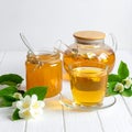 A jar of honey and a glass of hot jasmine tea in a teapot on a white wooden background Royalty Free Stock Photo
