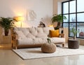 Interior of modern living room with warm sofa, houseplant on ottoman and glowing lamp Royalty Free Stock Photo
