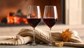 Glasses of wine, knitwear and blurred fireplace on background Royalty Free Stock Photo
