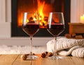 Glasses of wine, knitwear and blurred fireplace on background Royalty Free Stock Photo