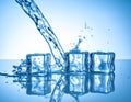 Ice cubes and splashing water on blue gradient background Royalty Free Stock Photo
