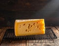 A piece of cheese on a grated and wooden table Royalty Free Stock Photo