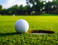 A close-up of a golf ball on the edge of a hole on a well-manicured green Royalty Free Stock Photo