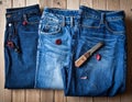 Three pairs of blue jeans are laid out on a wooden floor Royalty Free Stock Photo