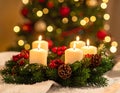 Christmas advent wreath with burning candles. Lights on x-mas tree in background Royalty Free Stock Photo