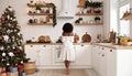 Holidays time, woman in cozy home interior, pretty kitchen, mix style. Rear View Royalty Free Stock Photo
