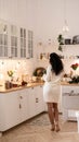 Holidays time, woman in cozy home interior, pretty kitchen, mix style. Rear View Royalty Free Stock Photo