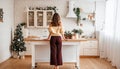 Holidays time, woman in cozy home interior, pretty kitchen, mix style. Rear View Royalty Free Stock Photo