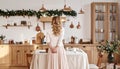 Holidays time, woman in cozy home interior, pretty kitchen, mix style. Rear View Royalty Free Stock Photo