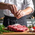 An experienced chef salts raw fresh beef before roasting or barbecuing. Working Royalty Free Stock Photo
