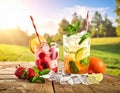 Two refreshing cocktails on a wooden table set against a sunny, grassy backdrop Royalty Free Stock Photo
