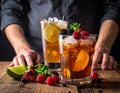 Two cocktails are on a wooden table, each in clear glasses filled with ice and garnished with slices of lime Royalty Free Stock Photo