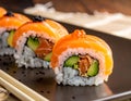 Sushi rolls are featured on a black rectangular plate Royalty Free Stock Photo