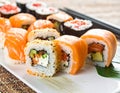 Assorted sushi plate featuring salmon nigiri and rolls. Salmon sashimi tops several rolls, Royalty Free Stock Photo