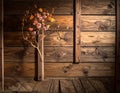 A branch with small, colorful flowers is placed against a wooden wall composed of horizontal planks Royalty Free Stock Photo
