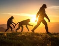Hominid figures walking in sequence against a setting sun, illustrating the concept of evolution. Royalty Free Stock Photo