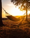Sunset with hammock in silhouette shadow with orange light effect. Royalty Free Stock Photo