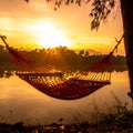 Sunset with hammock in silhouette shadow with orange light effect. Royalty Free Stock Photo