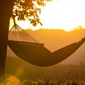 Sunset with hammock in silhouette shadow with orange light effect. Royalty Free Stock Photo
