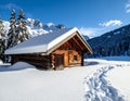 A wooden cabin is nestled in a snowy landscape, covered by a thick blanket of snow Royalty Free Stock Photo