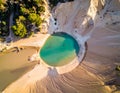 Circular turquoise pool situated amidst sandy, barren terrain Royalty Free Stock Photo