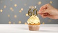 60th birthday. Woman lighting number shaped candles on cupcake at white wooden agains Royalty Free Stock Photo