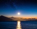 Moonlight reflects on a calm ocean under a starry night sky Royalty Free Stock Photo