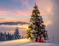Snow-covered Christmas tree with red and gold ornaments and lights, set against a picturesque winter landscape Royalty Free Stock Photo