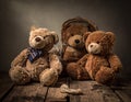 Three teddy bears are arranged on a rustic wooden surface. The left bear is light brown with a blue plaid bow tie. Royalty Free Stock Photo