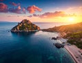 Coastal landscape at sunset showcasing a rugged island with rocky cliffs and dense green vegetation Royalty Free Stock Photo