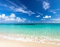 Turquoise ocean waves gently lap onto a soft, sandy beach under a vivid blue sky Royalty Free Stock Photo