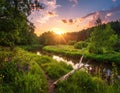 Sunset over a serene river winding through a lush, green landscape Royalty Free Stock Photo