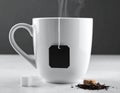 A white ceramic mug with a tea bag string and tag is set against a gray background Royalty Free Stock Photo