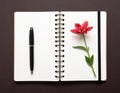 Open spiral notebook on a dark background with a black pen placed on the left page Royalty Free Stock Photo