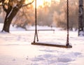 A wooden swing hangs from metal chains, covered with snow Royalty Free Stock Photo