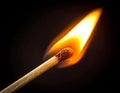 A single matchstick, with a wooden stem and a red phosphorus tip, is ignited Royalty Free Stock Photo