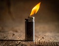 Metal lighter with intricate engravings stands upright on textured wooden surface Royalty Free Stock Photo