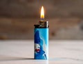 Blue plastic lighter with a metal top, featuring an artistic illustration of a face Royalty Free Stock Photo