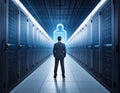 A man in a suit stands in a server room, flanked by tall, dark server racks on both sides Royalty Free Stock Photo