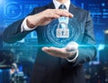 A businessman in a suit holds a holographic digital lock, symbolizing cybersecurity or data protection Royalty Free Stock Photo