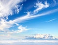 Snow-capped mountain peaks emerge from a sea of clouds under a vast blue sky Royalty Free Stock Photo