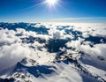 Snow-covered mountain peaks beneath a bright, radiant sun in a clear blue sky Royalty Free Stock Photo