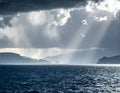 A dramatic seascape features a turbulent ocean under a dark, cloud-filled sky Royalty Free Stock Photo