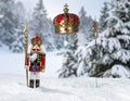 Christmas Nutcracker King wearing crown and holding scepter, snow covered evergreen t Royalty Free Stock Photo