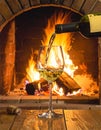 Art pouring wine by the fireplace Royalty Free Stock Photo