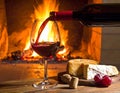 Art pouring wine by the fireplace Royalty Free Stock Photo