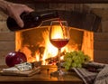 Art pouring wine by the fireplace Royalty Free Stock Photo