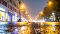 Rainstorm night in the big city, light from the shop windows reflected on the road Royalty Free Stock Photo